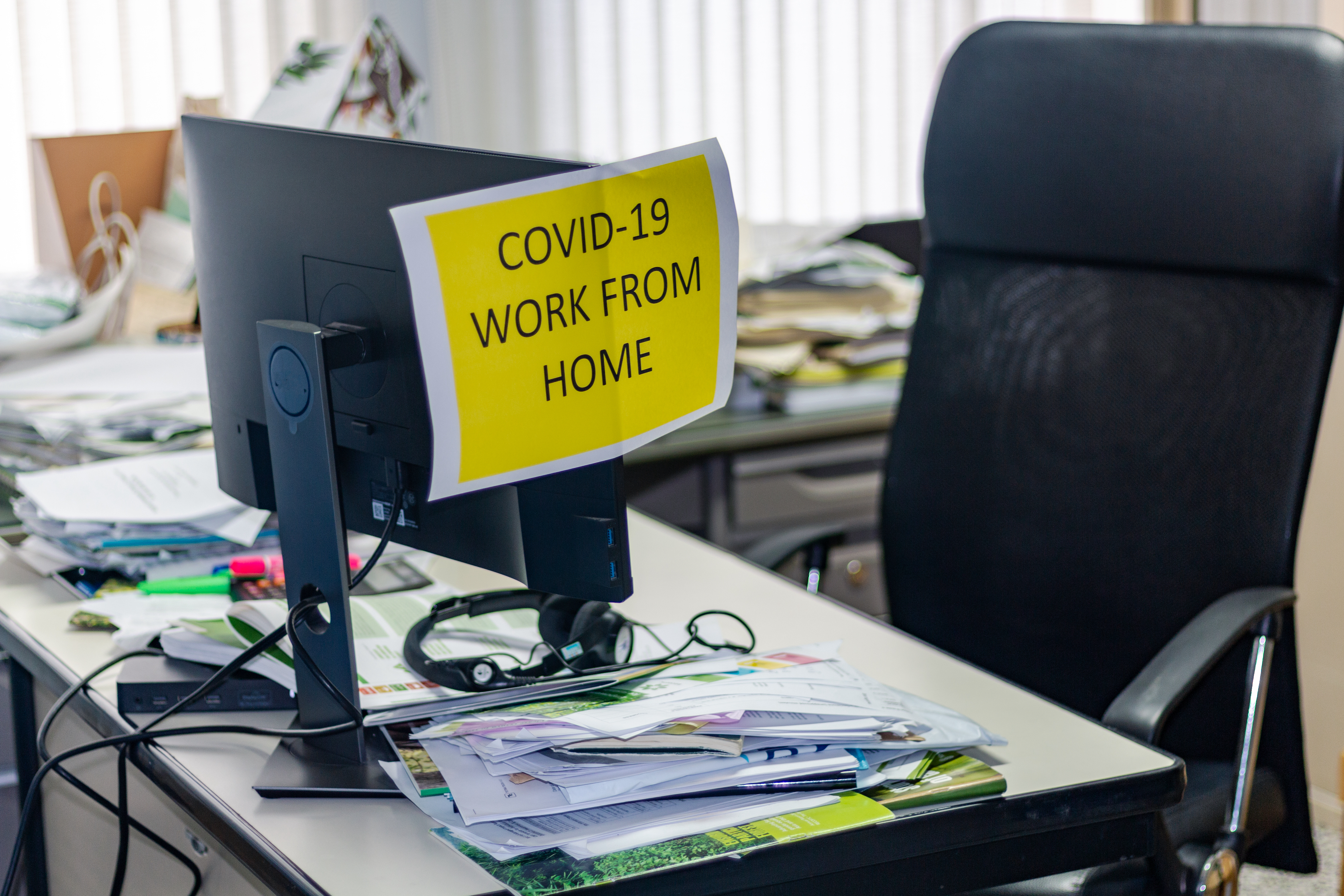imagen de un escritorio de oficina con un letrero que dice: covid 19, trabaja desde casa