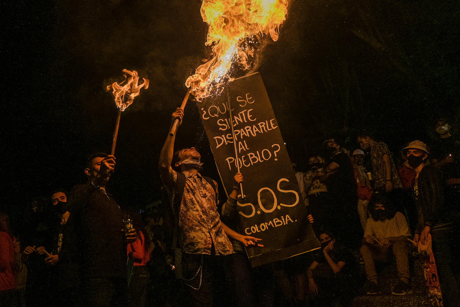 imagen de una persona con un cartel "S.O.S por Colombia"
